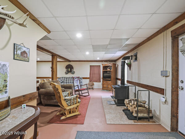 1498 Gainer Hill Rd, Dushore, PA 18614 - living room featuring a wood stove, a paneled ceiling, and recessed lighting