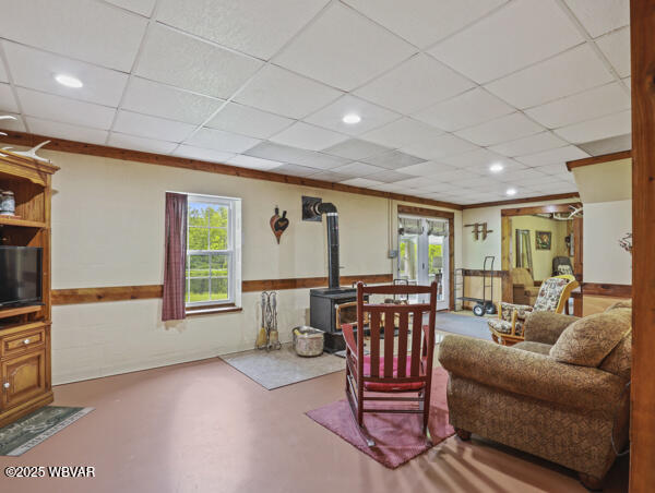1498 Gainer Hill Rd, Dushore, PA 18614 - living room with a wood stove, plenty of natural light, concrete flooring, a paneled ceiling, and french doors