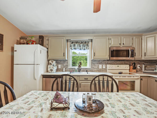 1498 Gainer Hill Rd, Dushore, PA 18614 - kitchen with white appliances, cream cabinets, light countertops, backsplash, and a ceiling fan