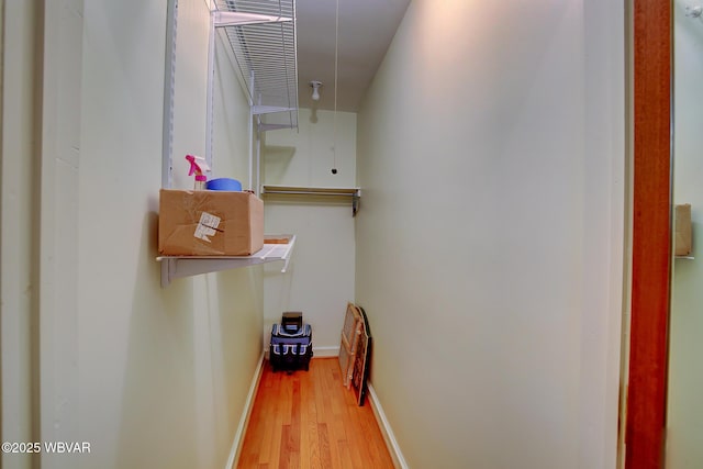 corridor with baseboards and wood finished floors