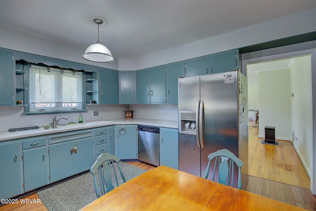 kitchen featuring light countertops, open shelves, appliances with stainless steel finishes, and blue cabinets