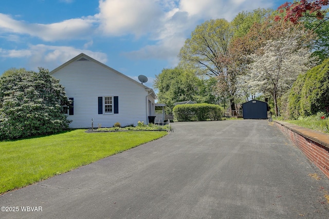 view of side of property featuring a yard, an outbuilding, and a shed