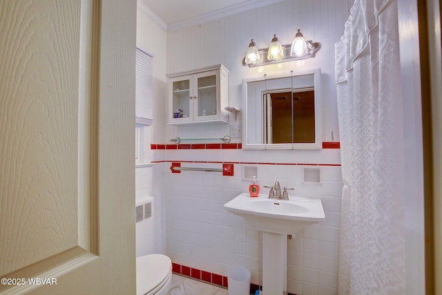 bathroom with crown molding, a sink, toilet, radiator heating unit, and tile walls