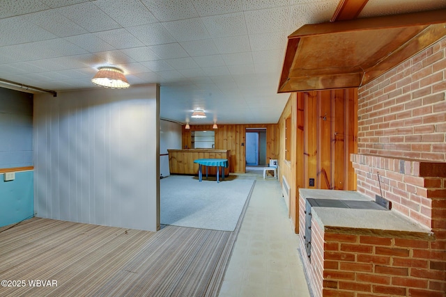 kitchen featuring wood walls and light carpet