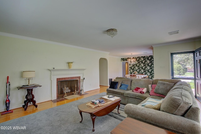 living area with crown molding, arched walkways, a chandelier, and visible vents
