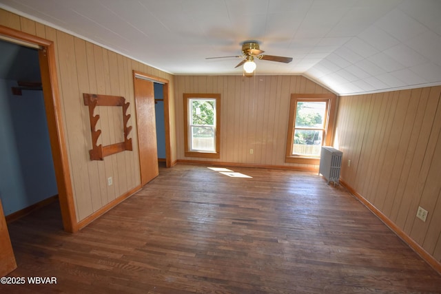 additional living space with plenty of natural light, dark hardwood / wood-style floors, radiator heating unit, and vaulted ceiling