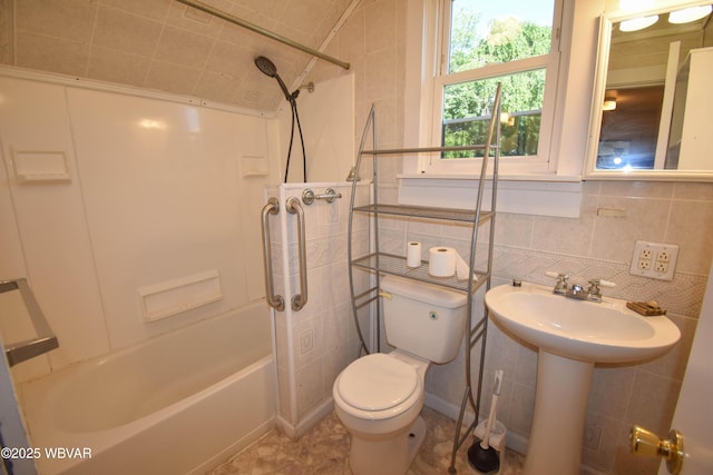 full bathroom with toilet, tile walls, decorative backsplash, sink, and shower / tub combination