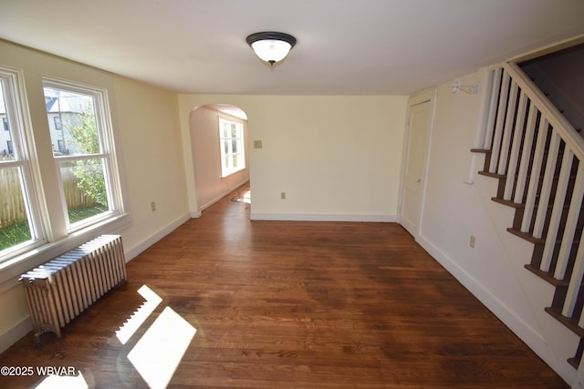 empty room featuring dark hardwood / wood-style floors and radiator