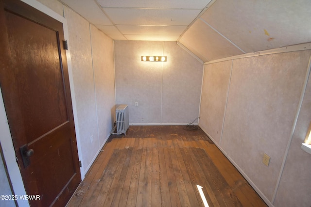 hallway featuring dark hardwood / wood-style floors, radiator heating unit, and vaulted ceiling