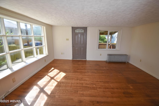 interior space with hardwood / wood-style flooring and radiator