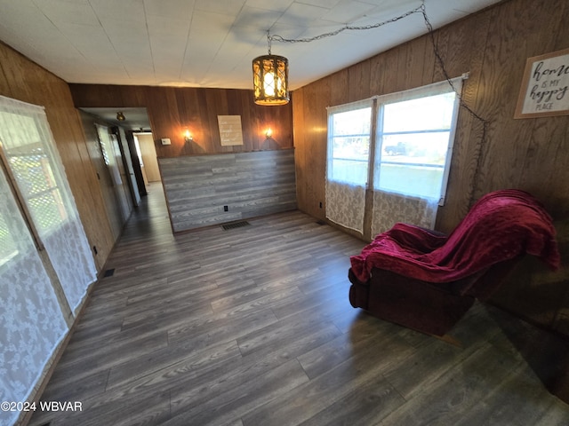 sitting room with dark wood-type flooring and wooden walls