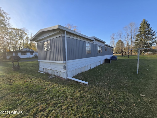 view of side of home with a playground and a lawn