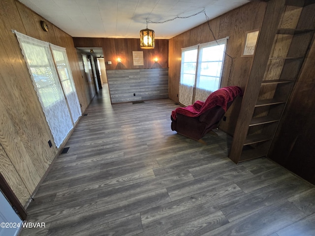 living area with dark hardwood / wood-style floors and wood walls