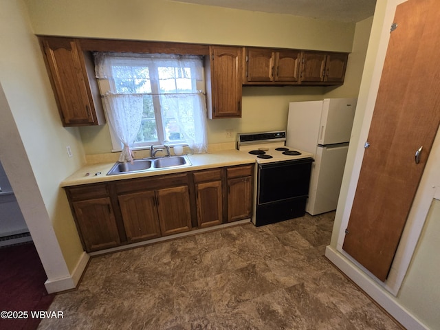 kitchen with electric stove, baseboard heating, sink, and white fridge