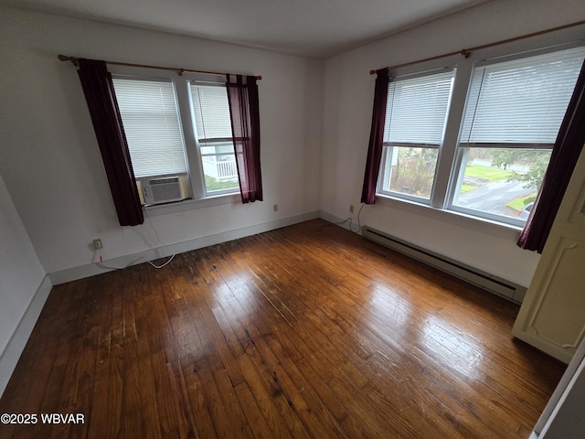 empty room with cooling unit, hardwood / wood-style flooring, a baseboard radiator, and plenty of natural light