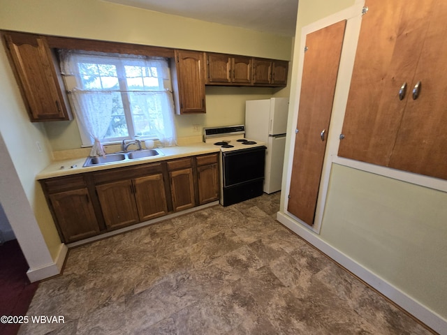 kitchen with white refrigerator, electric range oven, and sink