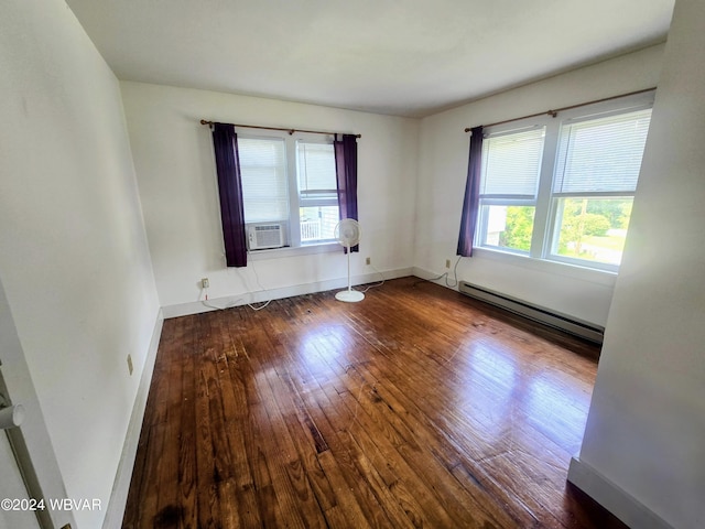 spare room with cooling unit, a baseboard radiator, and dark hardwood / wood-style floors