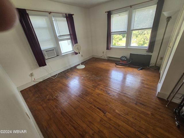 spare room featuring dark wood-type flooring, cooling unit, and baseboard heating