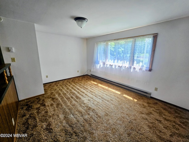 spare room featuring dark colored carpet and a baseboard heating unit