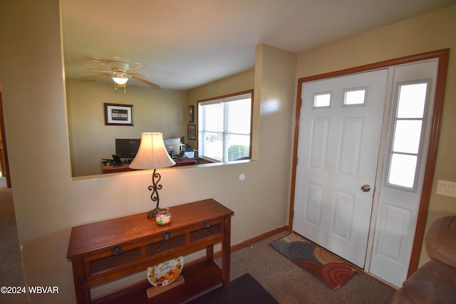 carpeted foyer entrance featuring ceiling fan