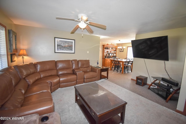 carpeted living room featuring ceiling fan with notable chandelier