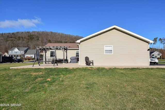 back of property featuring a pergola, a patio, and a lawn