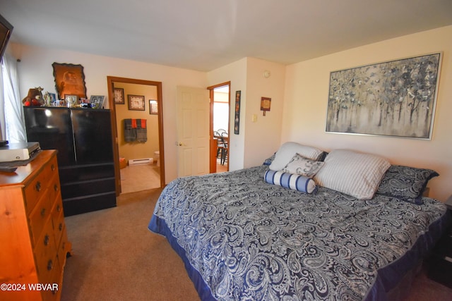 carpeted bedroom with ensuite bath, multiple windows, and a baseboard heating unit