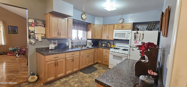 kitchen with white appliances, sink, and dark stone countertops