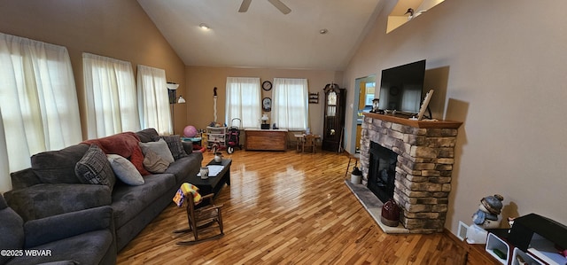 living room featuring ceiling fan, high vaulted ceiling, hardwood / wood-style floors, and a fireplace