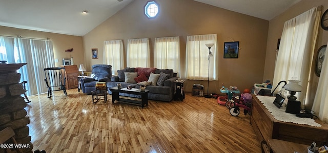 living room with high vaulted ceiling and light wood-type flooring