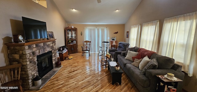 living room with high vaulted ceiling, hardwood / wood-style floors, and a fireplace