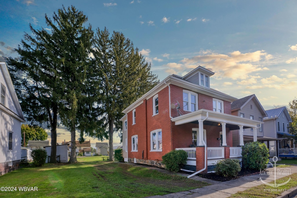 view of front of house featuring a yard and covered porch