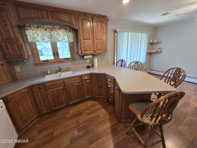 4401 Pine Mountain Rd, Jersey Shore, PA 17740 - kitchen featuring a breakfast bar, dark wood-style flooring, a peninsula, light countertops, and decorative backsplash