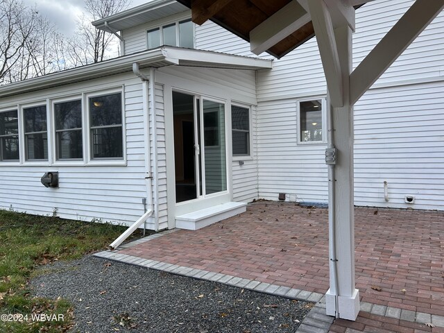 view of exterior entry with a patio