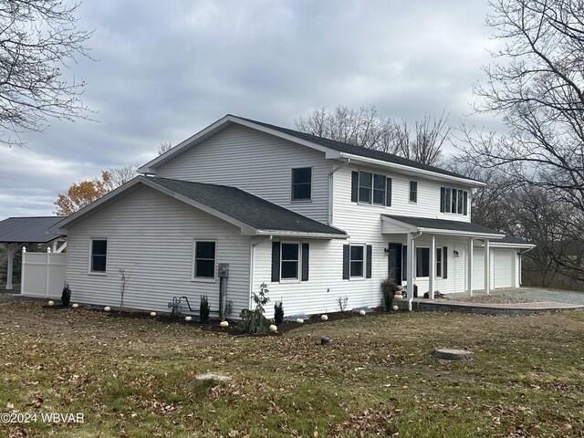 view of front facade with a garage, covered porch, and a front yard