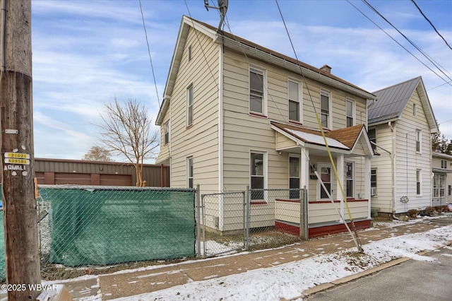 view of front of home featuring fence private yard, a gate, and a chimney