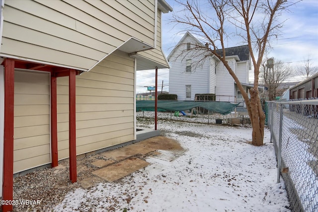 view of snow covered exterior with fence