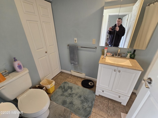 bathroom featuring toilet, vanity, tile patterned floors, and a baseboard radiator