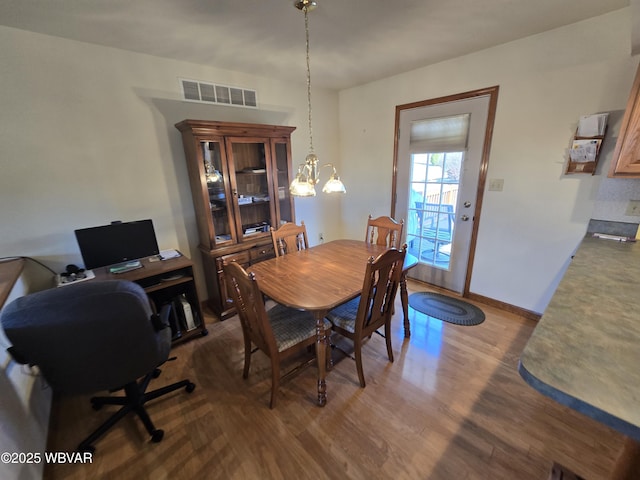 dining area featuring visible vents, baseboards, and wood finished floors