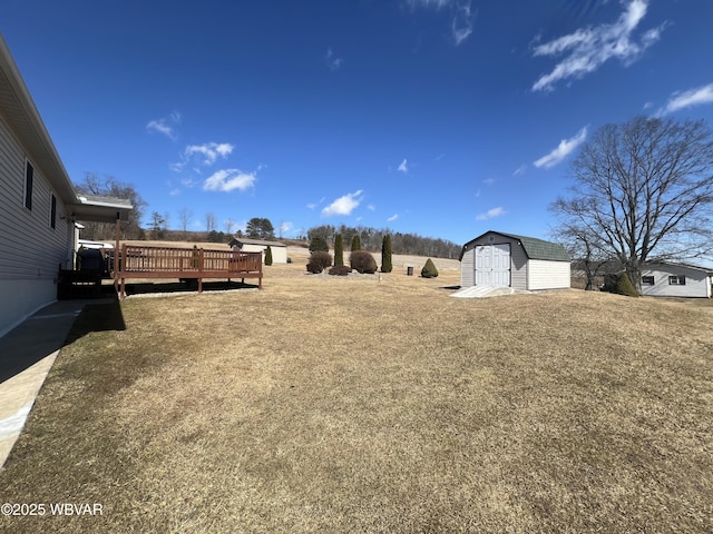 view of yard with a deck, a storage shed, and an outbuilding