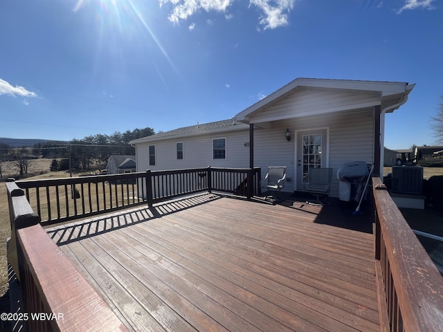 wooden deck featuring central AC unit and grilling area