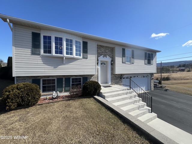 split foyer home featuring aphalt driveway and an attached garage