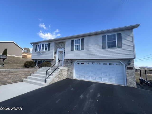 raised ranch with aphalt driveway and an attached garage