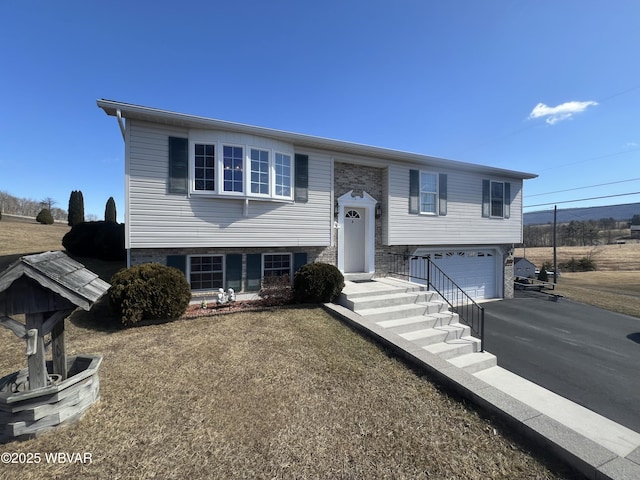 raised ranch with driveway and an attached garage