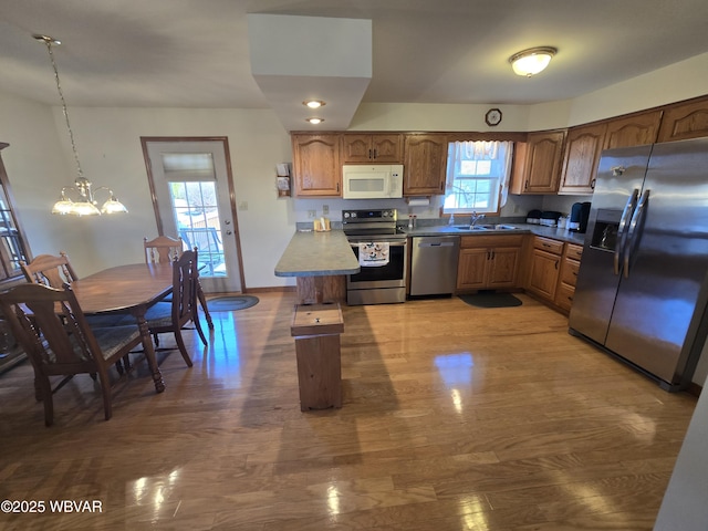 kitchen featuring plenty of natural light, appliances with stainless steel finishes, a sink, and wood finished floors