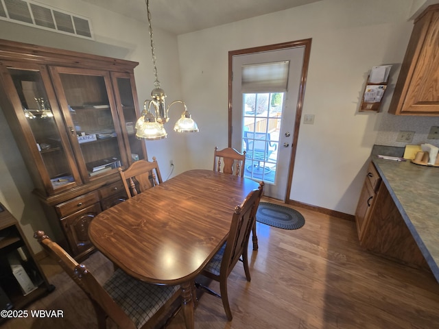 dining space featuring visible vents, baseboards, and dark wood-style flooring