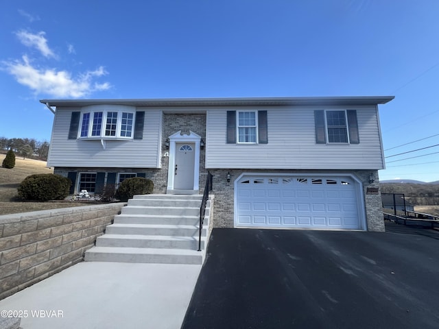 raised ranch with driveway and an attached garage