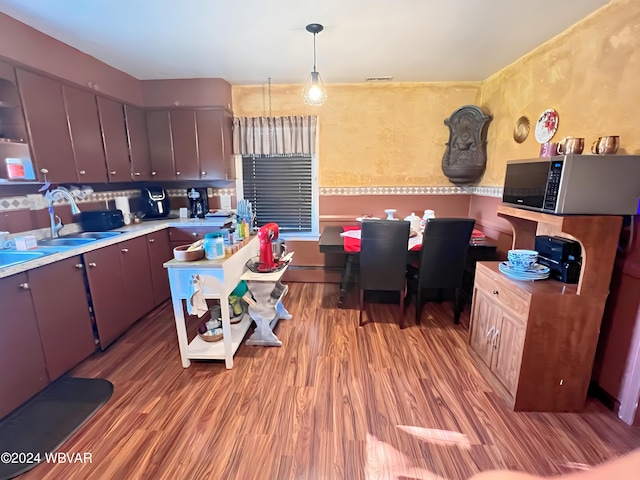 kitchen with sink, light hardwood / wood-style floors, and pendant lighting