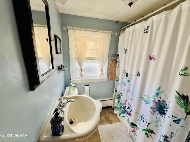 bathroom with sink, plenty of natural light, and a baseboard heating unit