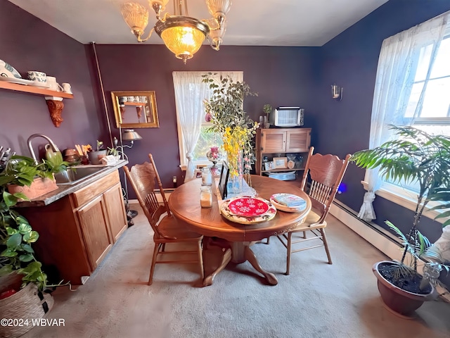 dining space featuring light carpet, a baseboard radiator, and a chandelier